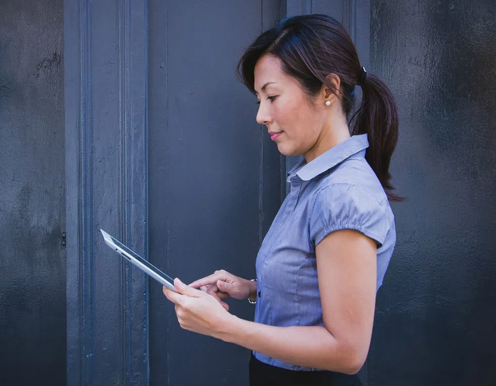 Professional Asian businesswoman checking and editing documents on a digital tablet
